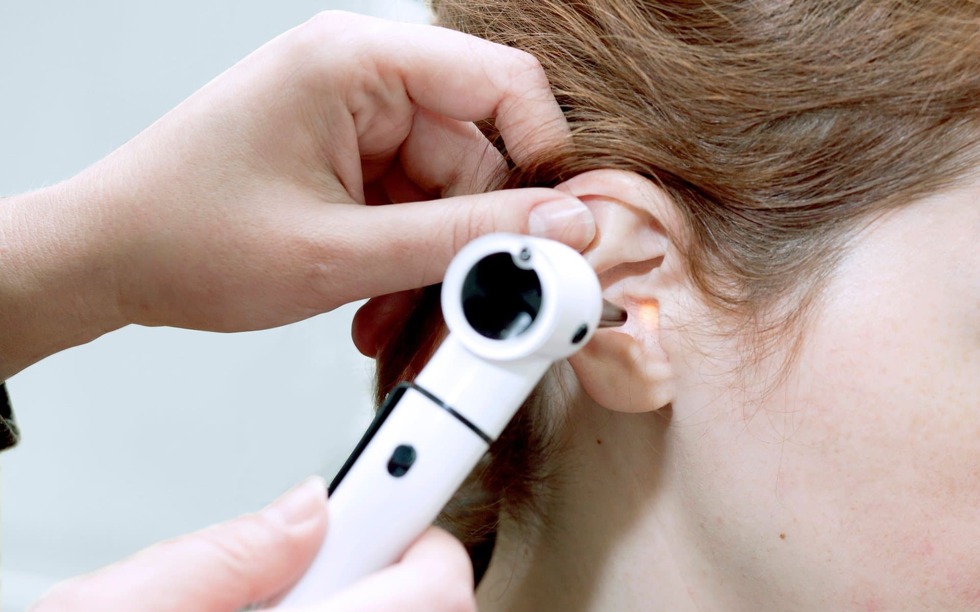 George Mustoe performing microsuction ear wax removal on a patient